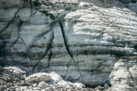 Minimalist nature background of glacier surface with cracks and scratches. Minimal natural backdrop of icy wall and blocks of ice from glacier close up. Beautiful nature texture of shiny glacial wall.の写真素材