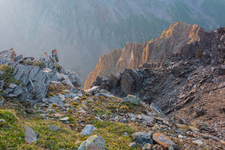 Awesome mountain view from cliff at very high altitude. Scenic landscape with beautiful sharp rocks near precipice and couloirs in sunlight. Beautiful mountain scenery on abyss edge with sharp stones.の写真素材