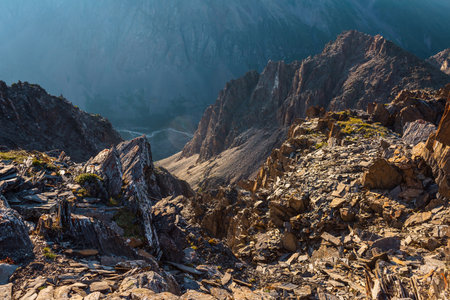 Awesome mountain view from cliff at very high altitude. Scenic landscape with beautiful sharp rocks near precipice and couloirs in sunlight. Beautiful mountain scenery on abyss edge with sharp stones.の写真素材