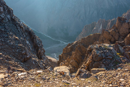 Awesome mountain view from cliff at very high altitude. Scenic landscape with beautiful sharp rocks near precipice and couloirs in sunlight. Beautiful mountain scenery on abyss edge with sharp stones.の写真素材