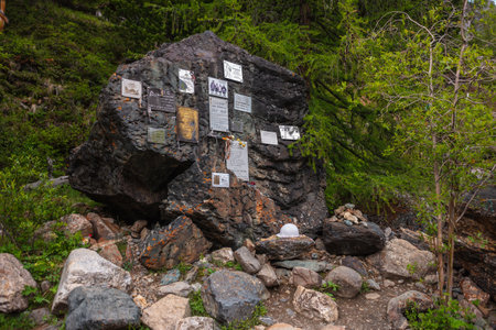 Monument to dead climbers in valley of Aktru river. Memory rock. Memorial to dead tourists in alpine camp in Aktru valley. Big memory stone. Russia, Altai Republic, Aktru mountain camp, 01 July, 2021.のeditorial素材