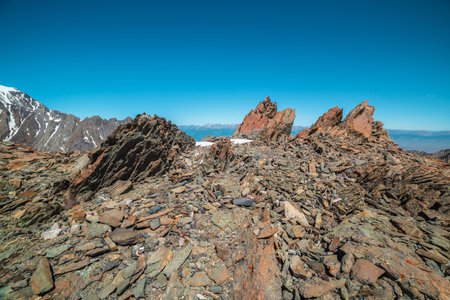 Scenic mountain landscape with old rocks and stones in sunlight. Awesome alpine scenery with stone outliers on high mountain under blue sky in sunny day. Sharp rocks in sunshine at very high altitude.の写真素材