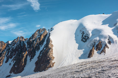 Minimalist mountain landscape with large glacier in sunlight. Simple snowy minimalism with glacial tongue in sunshine. Minimal alpine view to snow mountain tops at very high altitude in sunny day.の写真素材