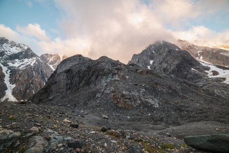 Scenic mountain landscape with sharp rocks in low clouds in golden sunrise colors. Awesome view to rocky mountain top in low clouds with golden dawn colors. Gold morning sunlight on high mountains.の写真素材