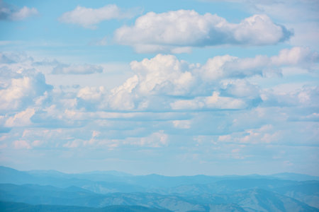 Scenic minimalist landscape with cumulus clouds in blue sky. Beautiful minimal view to cloudy sky. Simple minimalism with white clouds in blue sky. Colorful sky scenery. Atmospheric day cloudscape.の写真素材