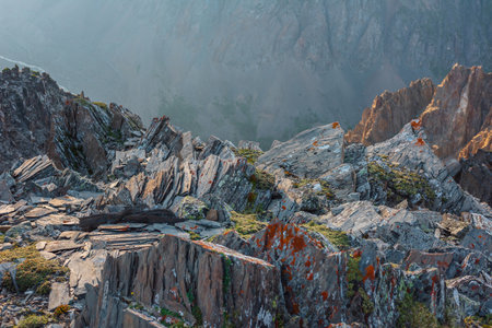 Awesome mountain view from cliff at very high altitude. Scenic alpine landscape with edge of precipice with sharp rocks against large mountain wall. Beautiful scenery on abyss edge with sharp stones.の写真素材