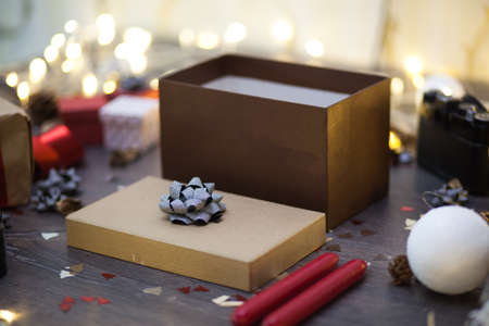 Brown gift box standing on a rustic wooden table with Christmas decorationsの写真素材