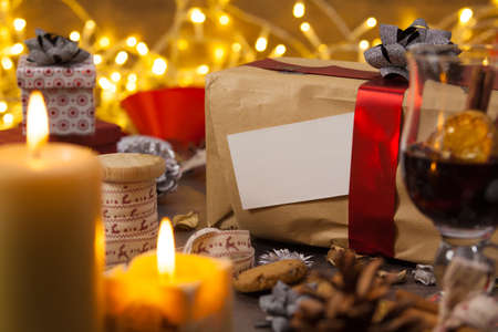 Brown gift box standing on a rustic wooden table with Christmas decorations, blank greeting cardの写真素材