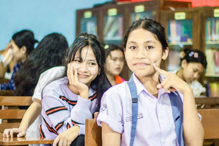 Muntilan, Indonesia - 26 Mar 2026: Two young Southeast Asian women smiling in a library. Happy...
