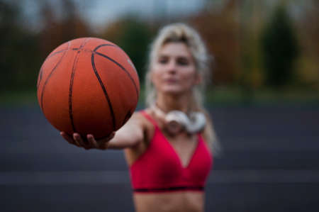 Beautiful sports girl holding ball looking at cameraの写真素材