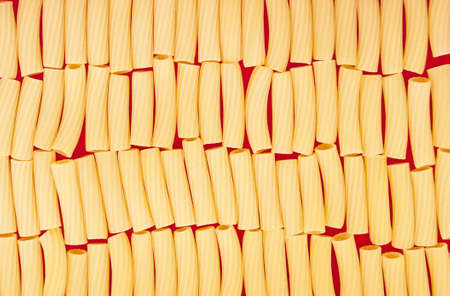 texture of italian pasta on red backgroundの写真素材