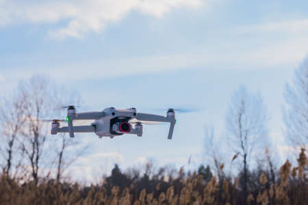 An unmanned quadcopter with a digital camera in the blue sky. high quality photoの写真素材