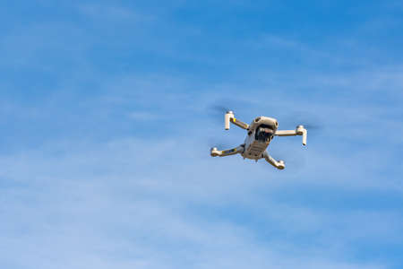 An unmanned quadcopter with a digital camera in the blue sky. high quality photoのeditorial素材