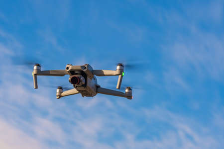 An unmanned quadcopter with a digital camera in the blue sky. high quality photoの写真素材