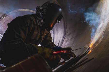 MMA welding. A welder welds large diameter pipes with manual electric arc welding. high quality...