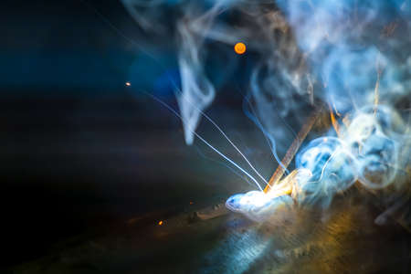 MMA welding. Welding with an electrode close-up. A welder welds large diameter pipes with manual...