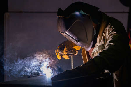 The welder welds metal structures by manual electric arc welding. MMA welding. high quality photoの写真素材