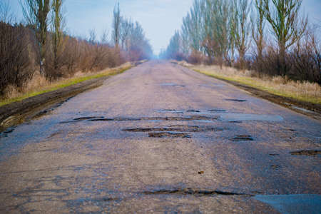 Poor quality road with potholes. Holes in the roadway. Risk of driving. high quality photoの写真素材
