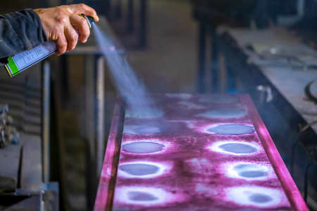 Spraying liquid penetrant to detect defects in welds. Detection of minor defects after the end of welding work. Testing of welded joints with a penetrating liquid. . high quality photoの写真素材