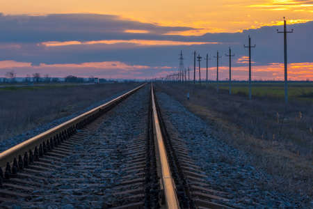 Railroad tracks during sunset. Power line running along the railway. high quality photoの写真素材