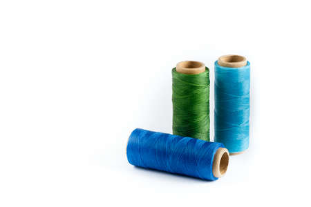 A skein of green, blue and cyan thread. Coils of colored threads on a white background. Waxed sewing...