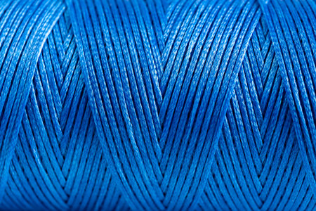 A coil of blue thread. Spool of colored threads on a white background. Waxed sewing thread for...