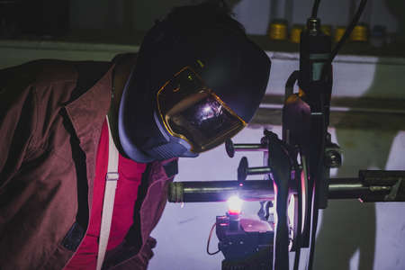 automatic welding machine. The welder monitors the quality of the welding process. Welding of stainless steel pipes in the environment of argon protective gas. high quality photoの写真素材