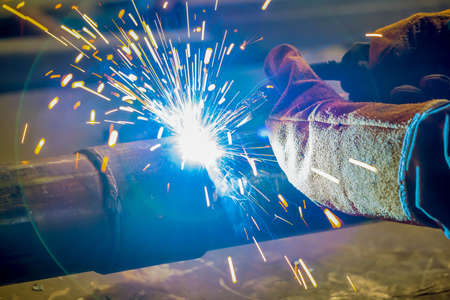 pipe welding. The connection of the pipe with a clamp. Welder performs welding work semi-automatic...