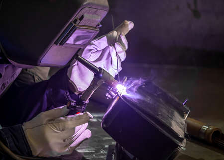 TIG welding. Welding the fuel tank of a motor pump by electric arc welding in argon shielding gas. high quality photoの写真素材