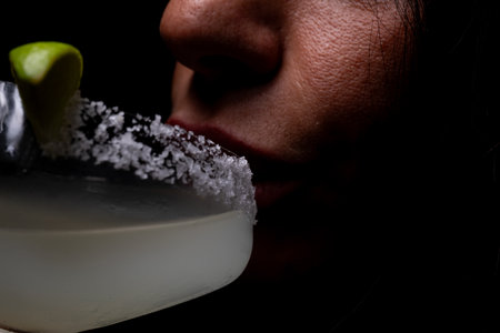 Close up of a woman's lips eating an apple on a martini glassの写真素材