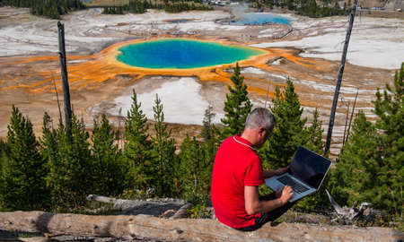 Business man at work in Grand Prismatic Spring, Yellowstone National Park, Wyomingの写真素材