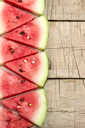 Bright watermelon slices on a wooden tableの写真素材