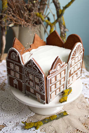 Honey cake decorated with gingerbread houses. Rustic style, selective focus.の写真素材