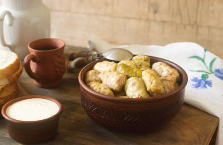 Cabbage rolls served with sour cream, bread and wine. Traditional Moldavian or Romanian Sarmale dish, traditional Russian or Ukrainian golubtsy. Selective focus.の写真素材
