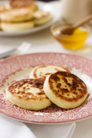 Cottage cheese pancakes, homemade syrniki with honey and sour cream. Selective focus.