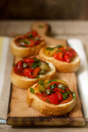 Fresh and tasty bruschetta with pickled bell pepper, capers and parsley.の写真素材