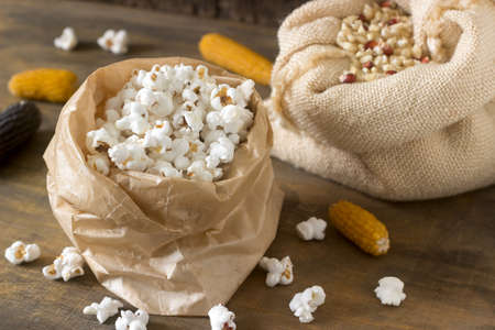 Pop corn, corn grain and cobs on a wooden background. Rustic style, selective focus.の写真素材