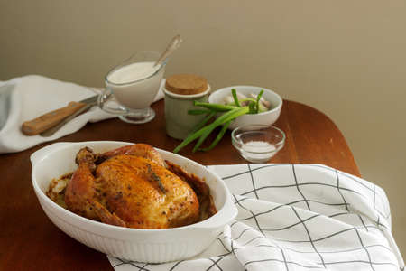 Baked chicken with herbs and garlic, served with sour cream sauce. Rustic style, selective focus.の写真素材