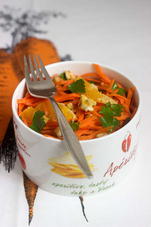 Juicy vitamin carrot salad with oranges, prunes and nuts. Rustic style, selective focus.の写真素材