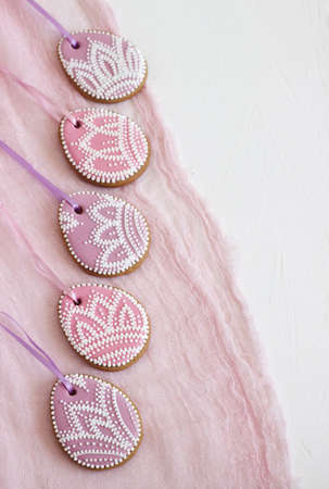 Homemade gingerbread Easter lilac and pink color in the form of egg with a floral pattern. Selective focus.の写真素材