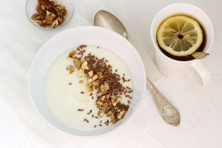Traditional semolina porridge with butter, nuts and flax seed. A useful breakfast of porridge and tea. Rustic style.の写真素材