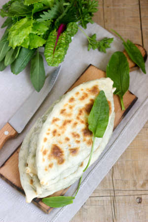 Baker making traditional dish of Armenians from Artsakh Zhingyalov hats is a type of flatbread stuffed with finely diced herbs and green vegetables. Selective focus.の写真素材