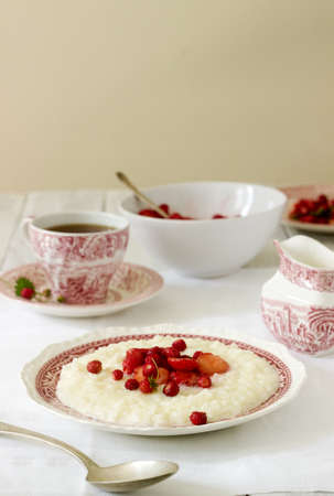 A useful breakfast of rice porridge with strawberry sauce served with tea. Selective focus.