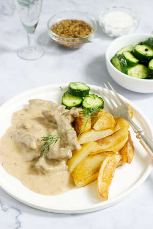 Beef Stroganoff - a traditional Russian dish of beef in sour cream sauce, served with fried...