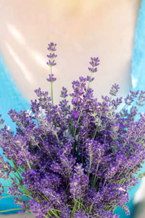 Woman on a sunny day holding a bouquet of fresh fragrant lavender. Rustic style, selective focus.の写真素材