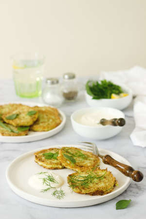 Pancakes from zucchini, served with sour cream or yogurt and various herbs. Useful vegetarian food....