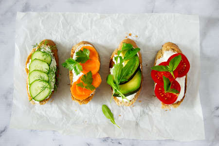 Various vegetarian sandwiches with useful bread, vegetables and herbs. Selective focus.