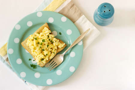 Simple classic breakfast of bread toast and scrambled eggs with parsley. Selective focus.の写真素材