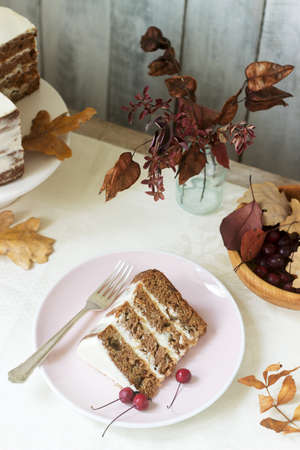 Apple cake with cream, decorated with small apples against the background of autumn composition....