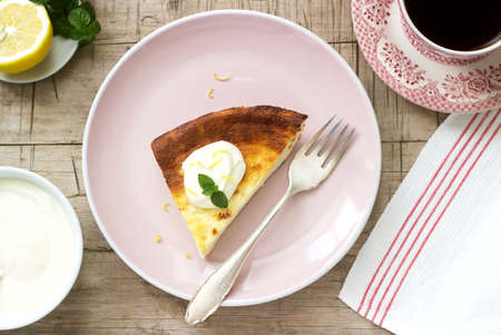 Healthy breakfast made from soft cottage cheese casserole with oatmeal and lemon zest, served with sour cream and mint.の写真素材